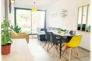 Una sala de estar con una mesa y sillas amarillas. en Villa VITA, piscine privée chauffée & jacuzzi privatif, 5mn des plages, en Porto Vecchio