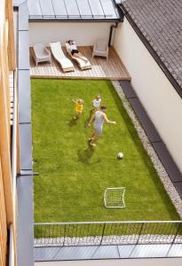 a group of people playing soccer on a lawn at das bleibt Alpine Suites in Schladming