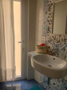 a bathroom with a white sink and a mirror at Camera matrimoniale LA LAMPUGA in Marettimo