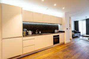 a kitchen with white cabinets and a black refrigerator at Piccadilly Place in York