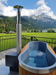 a hot tub on a deck with a view of a mountain at Braito's Seaside Lodges und Suites in Haldensee