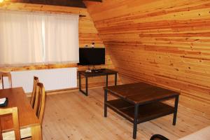 una habitación con 2 mesas y TV en una cabina en Borjomi Cottage Sadgeri en Sadgeri