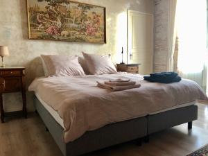een slaapkamer met een groot bed en handdoeken bij MaDamenFrance in Monclar-dʼAgenais