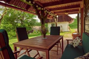 a wooden table and chairs on a patio at Srčna, Tri Vile, a beautiful log cabin with amazing view in Podčetrtek