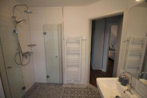 Un baño con ducha, lavabo y espejo. en Strandglück, en Horumersiel 18 fotos más