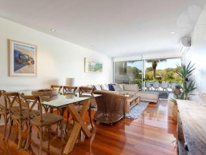 a living room with a table and chairs at Bennetts by the Beach in Hawks Nest
