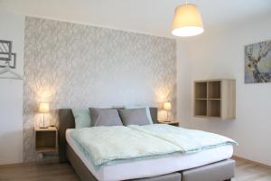 Un dormitorio con una cama grande y dos lámparas. en Haus Luna, en Bütgenbach