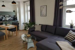 a living room with a blue couch and a table at Ferienwohnung im alten Waschhaus in Spremberg