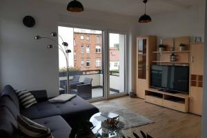 a living room with a blue couch and a television at Ferienwohnung im alten Waschhaus in Spremberg