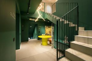 un pasillo con una mesa amarilla y escaleras en Elide Design Hotel, en Asís
