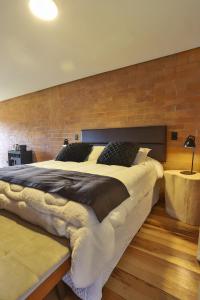 a large bed in a room with a brick wall at DOM Hotel Boutique in Campos do Jordão