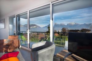 una sala de estar con una gran ventana con vistas a las montañas en Appartement Tournette - Vue Lac en Sévrier
