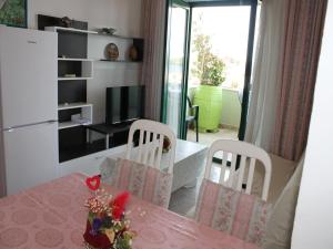 een keuken met een tafel en twee stoelen en een televisie bij Apartment in Kali with sea view, balcony, air conditioning, Wi-Fi (4566-3) in Kali