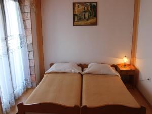 een bed in een slaapkamer met een lamp op een tafel bij Apartment in Kali with sea view, balcony, air conditioning, Wi-Fi (4566-3) in Kali