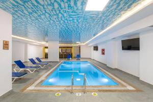 a pool in a building with a blue ceiling at TAMARA Business Otel in Antalya