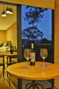 a wooden table with two wine glasses on it at DOM Hotel in Campos do Jordão