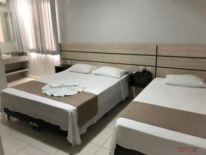 a hotel room with two beds in a room at Dallas Hotel in Palotina