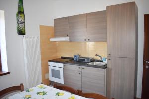 una pequeña cocina con fregadero y nevera. en VILLA CLANI apartment, en Colà di Lazise