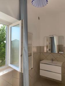 bagno con lavandino e finestra di La Terrazza Sul Ciliegio a Marino