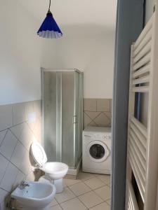 a bathroom with a toilet and a washing machine at La Terrazza Sul Ciliegio in Marino