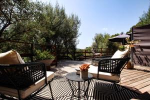 a patio with two chairs and a table on a deck at Chambre d'hôtes A Vadina Porticcio in Porticcio