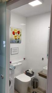 ベナルマデナにあるEstudio Benalmádenaのバスルーム(トイレ付)が備わります。壁に絵画が飾られています。
