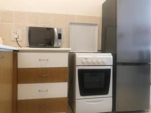 uma cozinha com um micro-ondas, um fogão e uma televisão em Sea view Apartments Portobello em St. Paul's Bay