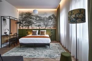 1 dormitorio con 1 cama y una pintura en la pared en Urban Yard Hotel, en Bruselas