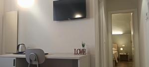 a room with a desk and a television on the wall at Hotel Cavallo Bianco in Reggiolo