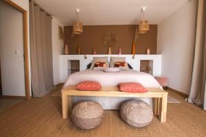 a bedroom with a bed with two ottomans on it at Chambre d'hôtes A Vadina Porticcio in Porticcio