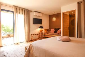 a bedroom with a bed and a couch and a window at Chambre d'hôtes A Vadina Porticcio in Porticcio