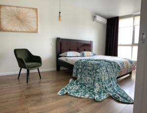 um quarto com uma cama e uma cadeira em Дизайнерський ремонт&центр& VIP, ЕЛЕКТРОЗАПРАВКА на території будинку em Rivne