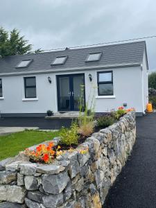 a stone retaining wall in front of a house at Tigh Noor - Escape to Kinvara by the sea! in Galway