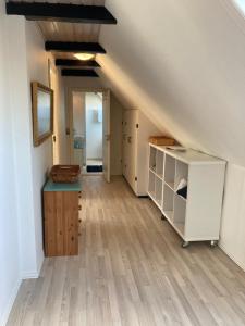 an attic room with a staircase with a wooden floor at Kallerup Hgård in Thisted