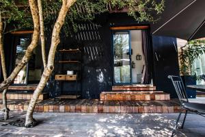 a black house with a tree in front of it at Chambre d'hôtes A Vadina Porticcio in Porticcio