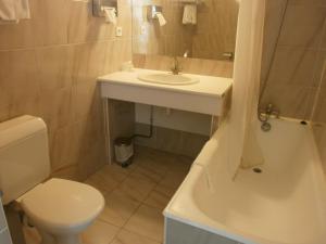 a bathroom with a sink and a toilet and a tub at Hôtel Le Richiardi in Carqueiranne +34 photos