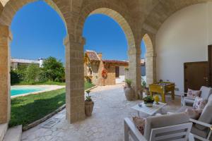 um pátio exterior com arcos e uma piscina em Villa Raffaella by BarbarHouse em Spongano