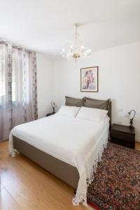 Farra di SoligoにあるVinai UNOのベッドルーム(白いベッド1台、シャンデリア付)