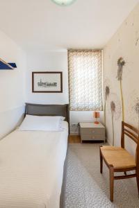 Farra di SoligoにあるVinai UNOのベッドルーム1室(ベッド1台、椅子、テーブル付)