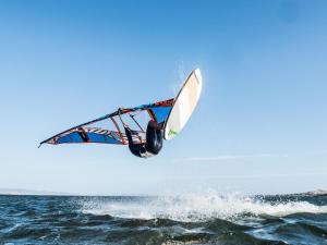 a man flying through the air while riding a windsurfing at Cià Evelina in SantʼAntìoco