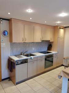 a kitchen with wooden cabinets and a sink at Steinbock in Grächen