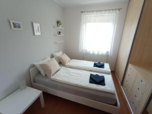 ein kleines Schlafzimmer mit einem Bett und einem Fenster in der Unterkunft Budapest Airport Apartment in Budapest