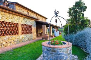 einen Garten mit einem Brunnen vor einem Steingebäude in der Unterkunft Villa Le Ginestre in Parrano