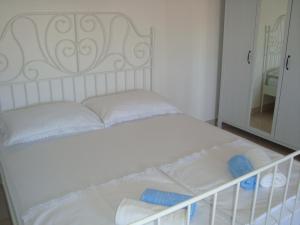 een wit bed met blauwe kussens in een slaapkamer bij Apartment SEA STAR in Hvar