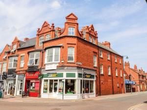 a large red brick building on a city street at Flat 1 in Prestatyn