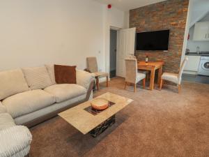 a living room with a couch and a table at Flat 1 in Prestatyn