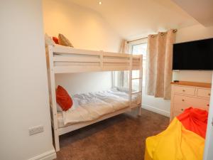 a bedroom with two bunk beds and a flat screen tv at Flat 1 in Prestatyn