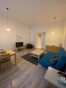 een woonkamer met een blauwe bank en tafels bij Apartament Vistula in Krakau