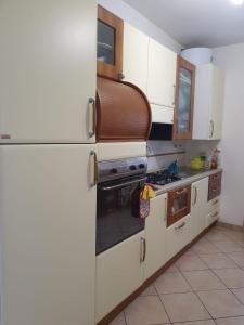 a kitchen with white cabinets and a stove top oven at Flamignano: un paradiso nel verde in Tossicia