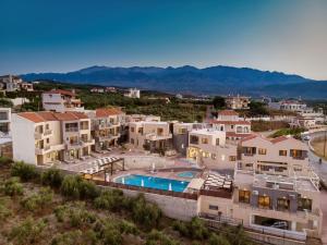 a group of houses with a swimming pool in a city at Sunrise Suites & Apartments in Kalyves